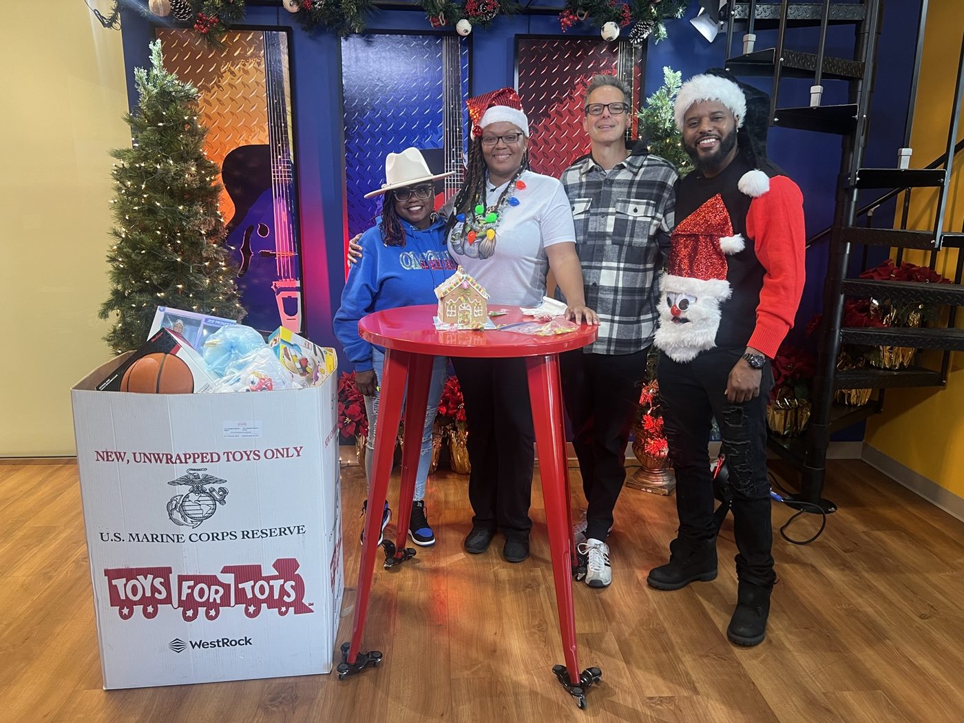 Marlon and partners at a Toys for Tots holiday drive in a studio
