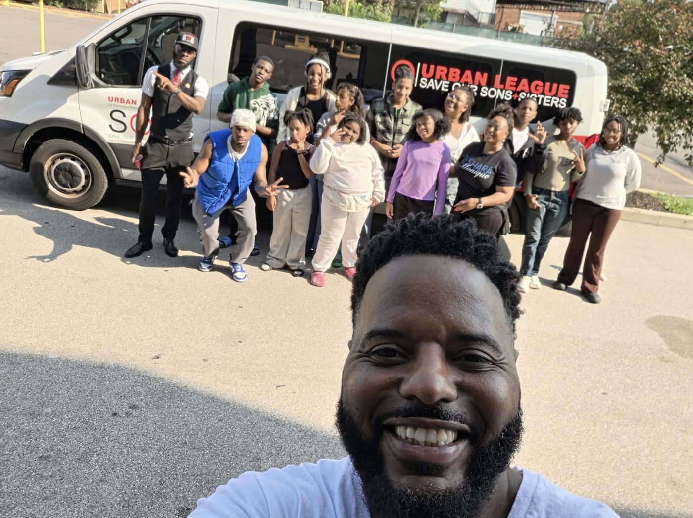 Marlon with Save Our Sons and Sisters participants in front of the Urban League van