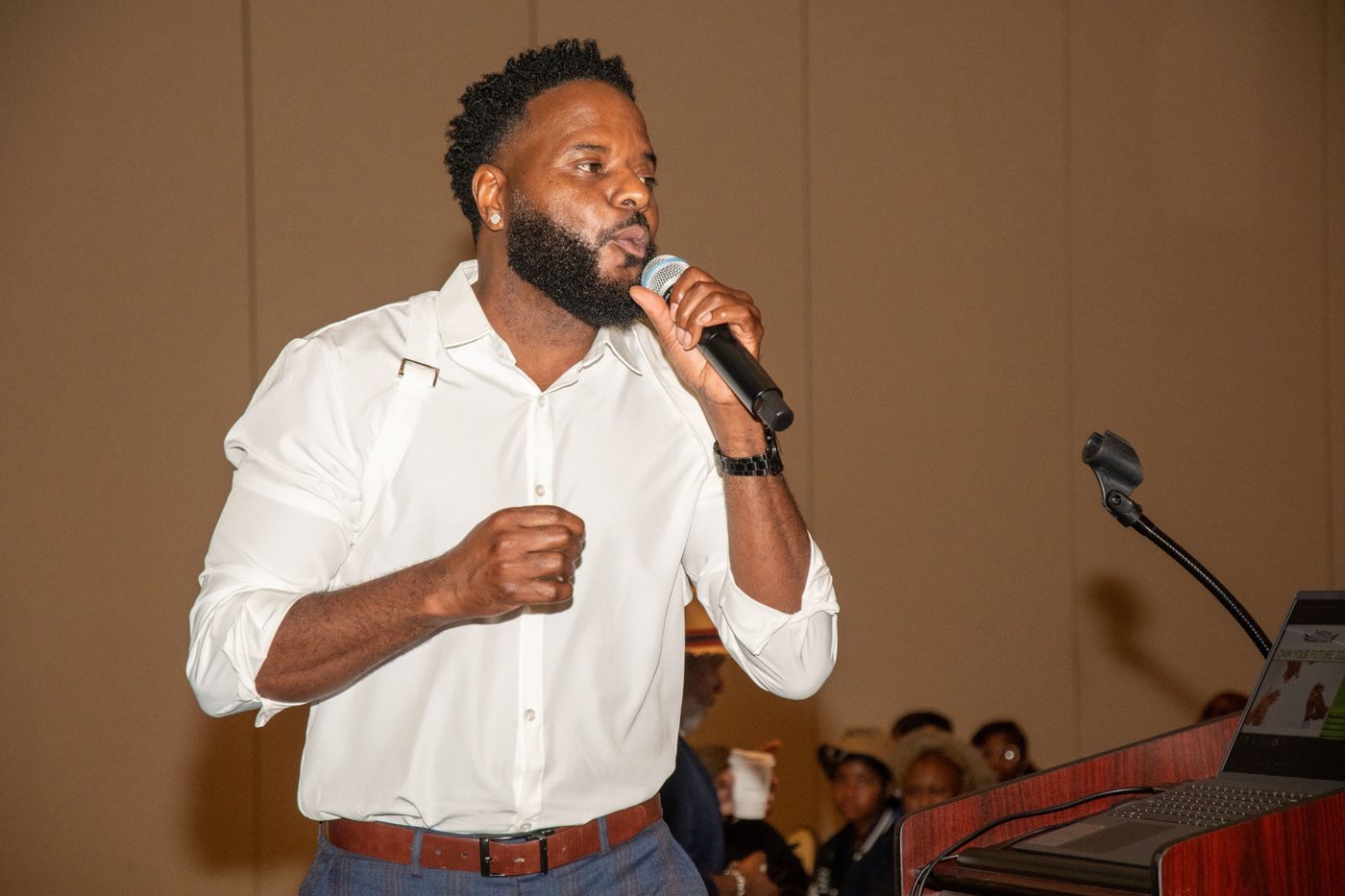 Marlon speaking into a microphone at a workshop